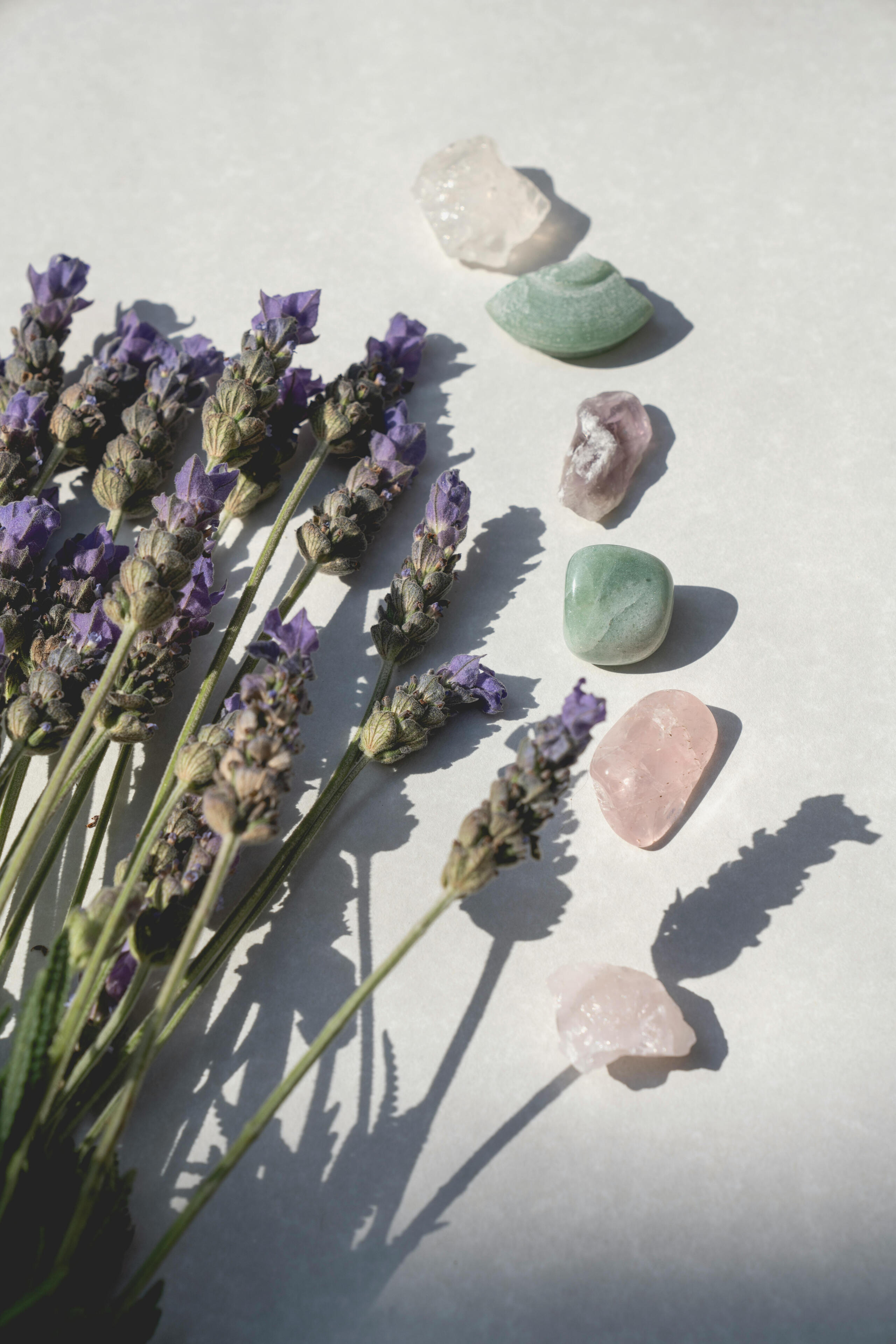 Selection of relaxing crystals alongside some sprigs of calming lavender